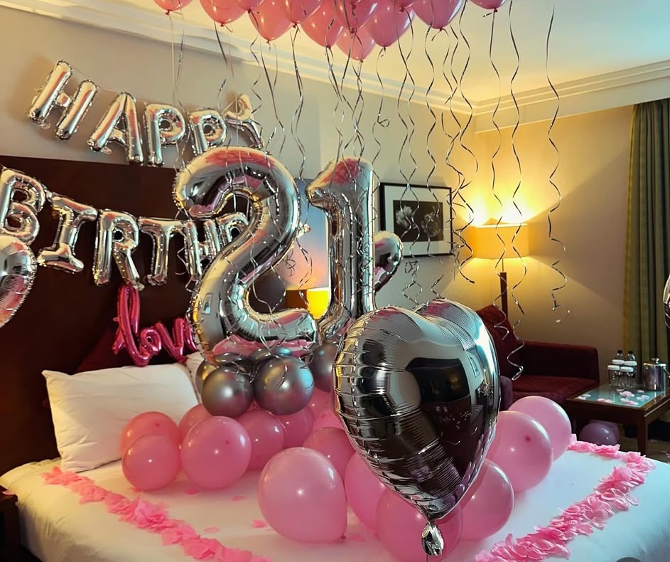 Pink balloons and silver 21st birthday decorations in a hotel room